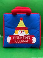 Closed blue fabric case with embroidered clown and Counting Clown text