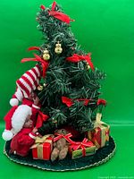 Full view of tabletop Christmas tree display showing elves, presents and base