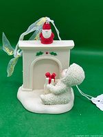 Front view of Snowbaby ornament showing fireplace, gift and gnome