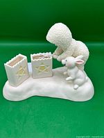 Front view of Snowbabies figurine with candle holders and rabbit