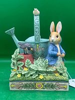 Front view of Peter Rabbit, bird, watering can figurine