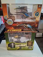 Front view of both boxed Propel Stinger helicopters showing colors and packaging