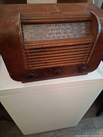 Front view of RCA Victor wooden tabletop radio showing dial, grille and knobs