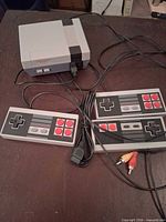 Console, two controllers, and composite AV cable laid out on table