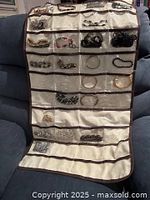 Full view of hanging organizer showing multiple bracelets in clear pockets
