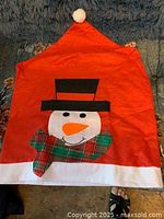 Single chair cover laid flat showing snowman design and pom-pom