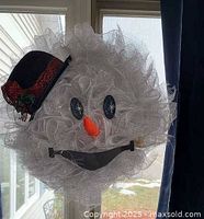 Front view of white tulle snowman wreath with hat, nose, mouth
