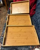 Three wooden trays laid out side by side