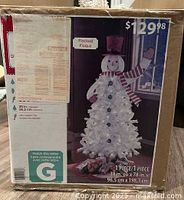 Box front displaying snowman tree image and dimensions