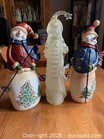 Front view of all three snowman figurines standing on table