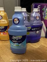 Blue and purple Swiffer WetJet cleaner bottles front and back of image