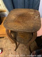 Full view of wooden plant stand showing square top and curved legs