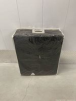 Mat folded inside clear plastic storage bag with handle