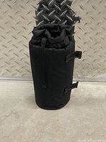 Cylindrical black insulated bottle cooler bag standing upright
