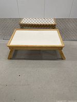 Tray table front view, legs extended; footstool behind