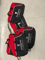 Group of red and black messenger bags showing color, straps and front branding