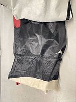 Folded black fabric with white backing and small red portion