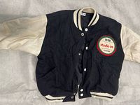 Front view of varsity jacket showing patch and snap closure