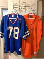 Three jerseys hanging: orange BC Lions, blue Buffalo Bills #78, white mesh behind