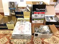 Group of boxed door knobs and locks from multiple brands