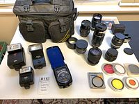 Overall lot showing Nikon bag, eight lenses, three flashes, Gossen meter, filters