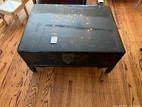 Full view of black lacquer trunk on legs