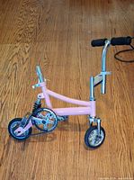Full view of pink clown bicycle showing frame, wheels, handlebar