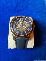 Front view of Fossil skeleton watch on pillow