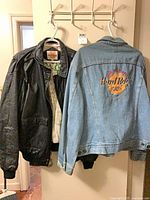 Black leather jacket and blue denim Hard Rock Cafe jacket hanging
