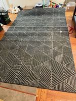 Full view of rug laid out on floor showing geometric pattern and size
