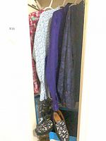 Closet view showing four shirts on hangers and Fluevog shoes below