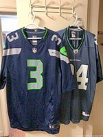 Front view of both Seahawks jerseys on hangers