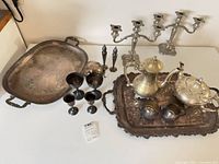 Group shot of entire lot showing trays, goblets, shakers, candelabras, coffee pot set