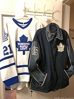 Bomber jacket and jersey hanging side by side showing front details and numbers