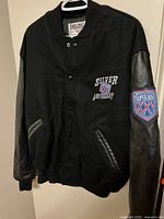Front view of varsity jacket showing chest patch and leather sleeves