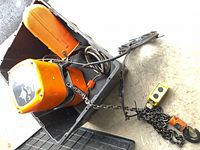 Hoist in tote showing housing, chain, pendant, hook