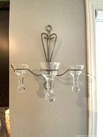 Single sconce mounted on wall with three glass inserts in place