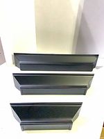 Front view of the three black wall shelves stacked by size