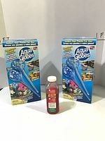 Front view of two Aqua Globes boxes and hummingbird food bottle