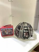 Lamp shade and lunch box side by side for scale