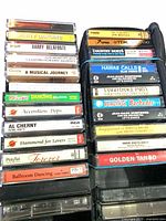 Two stacks of cassette tapes in case, titles visible
