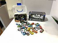 Grouped view of boxed OPP car, loose cars spread out, and tub containing more cars