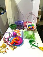 Overview of baskets, eggs, grass filler, discs, ropes, toys on table