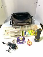 Overall lot showing bag, tackle box with lures, reel, line spools, flashlight