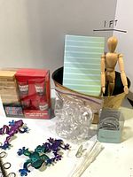 Group shot showing most items including Drunken Tower game, frogs, shower rings, mannequin in bucket, notebook