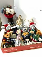Group shot showing Santa plush, resin figurine, snowman figure and box of miniature plush animals