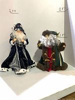 Both Santa tree toppers side by side with hand-written 2 ft height reference