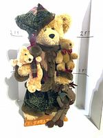 Front view of main teddy bear with three smaller plush animals