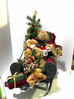 Front view of metal sleigh with plush bears, tree, gifts