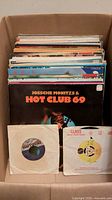 Box of assorted LPs and 45s, front record Hot Club 69 visible